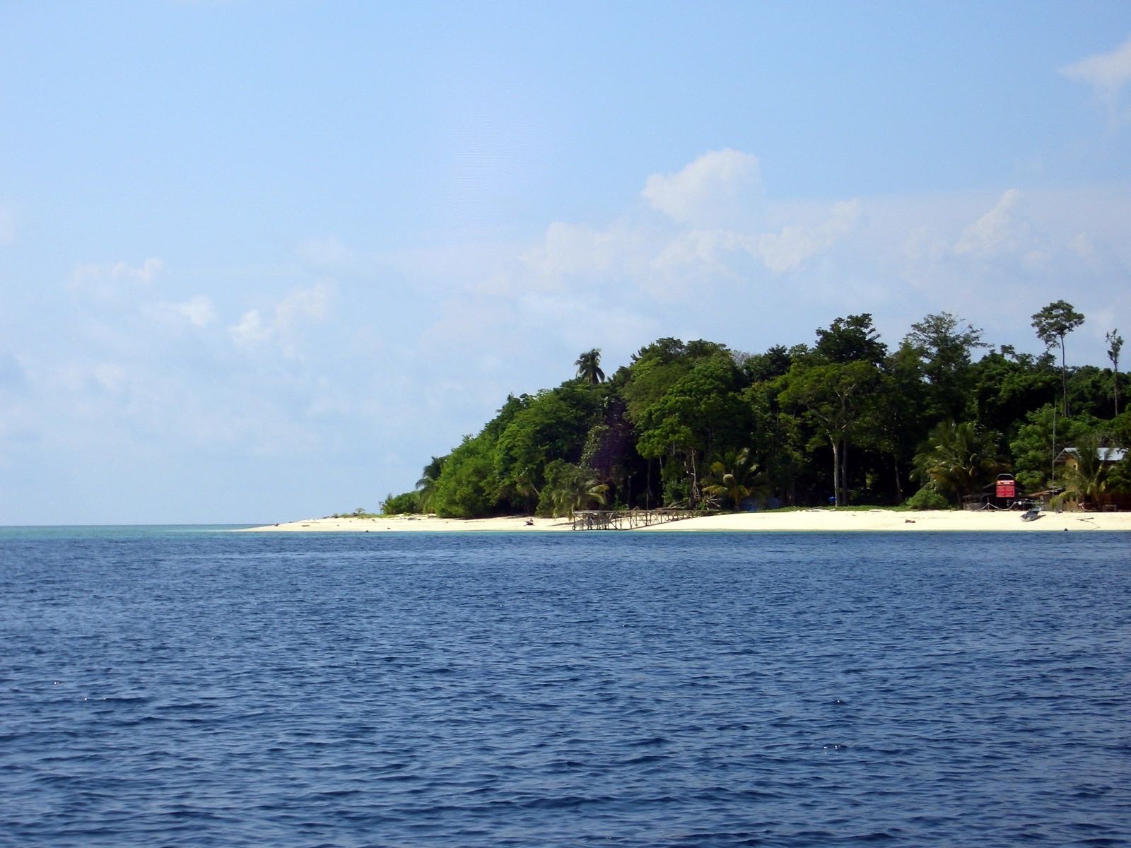 Sipadan Island seen from the sea, with its white-sand shore and dense tropical forest, Sabah.