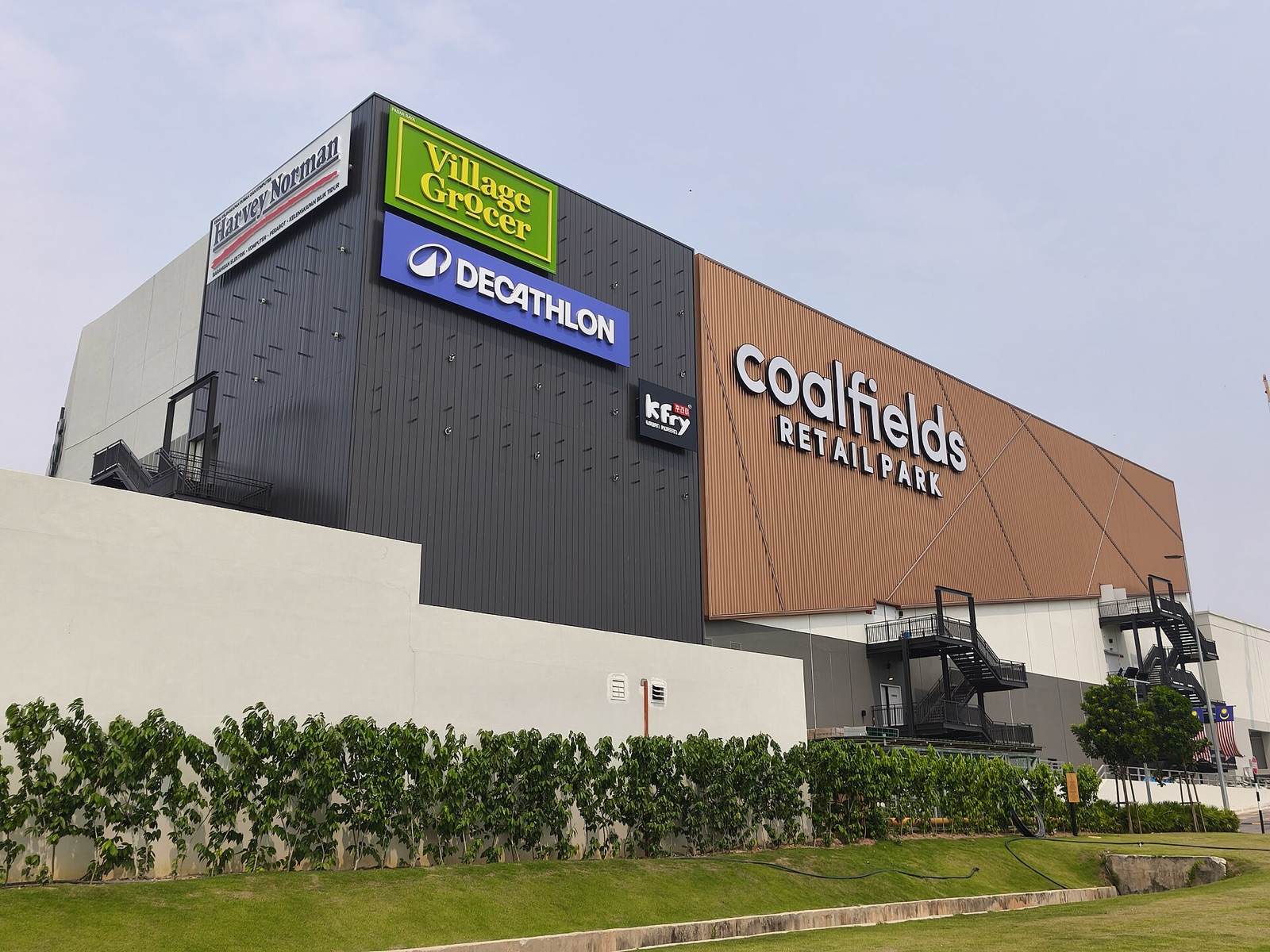 The Coalfields Retail Park facade, with the Village Grocer and Decathlon signs.