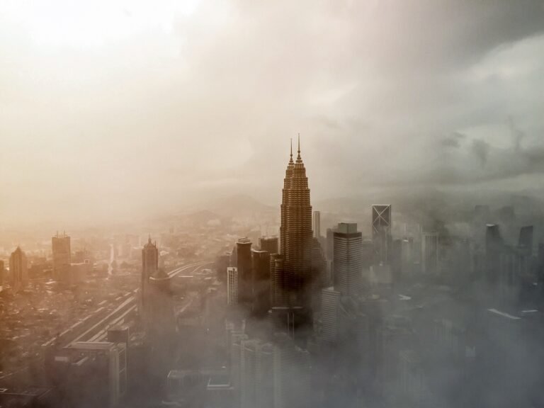 Tall skyscrapers in Kuala Lumpur wreathed in a dense fog.