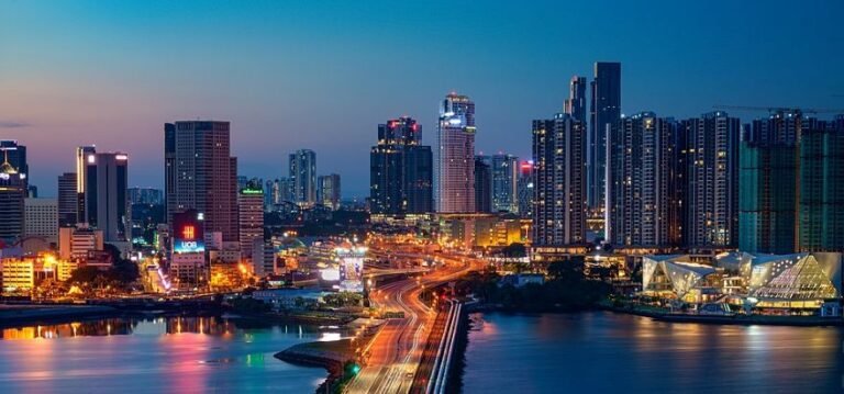 Panoramic view of Johor Bahru skyline seen from the causeway linking Malaysia to Singapore, with skyscrapers in the distance.